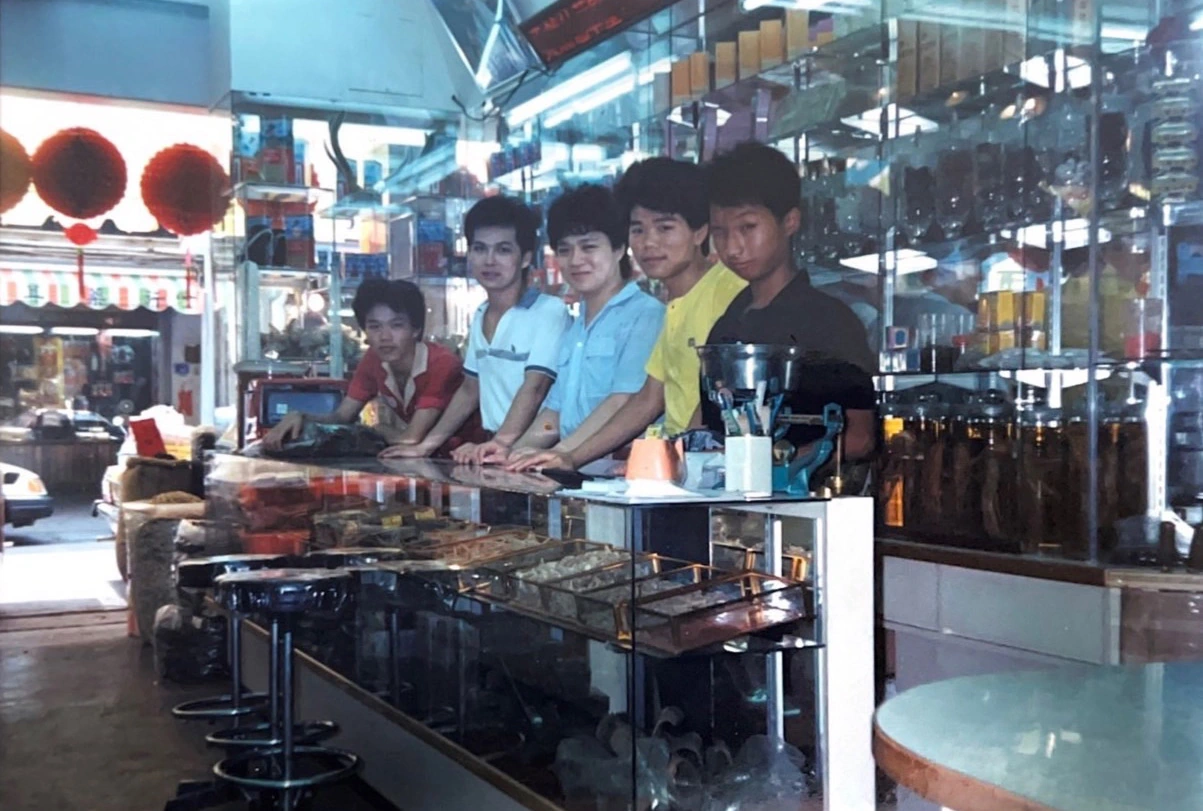 早年中藥行店內，櫃檯後方的店員與陳列的中藥材